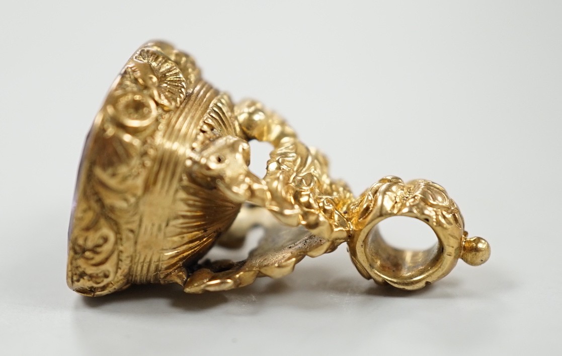 A 19th century yellow metal overlaid and amethyst set fob seal, the matrix carved with flowers and motto, 27mm.